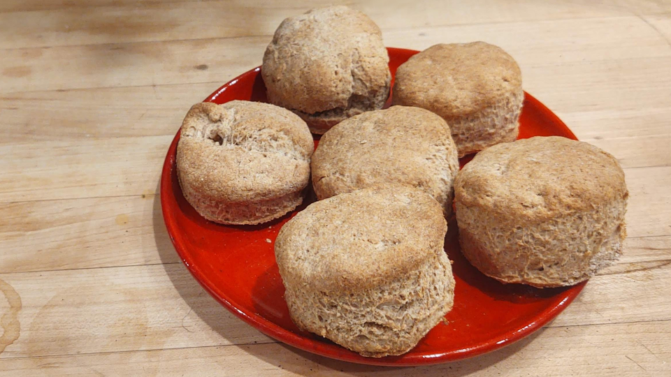 Buttermilk spelt biscuits on a red plate.